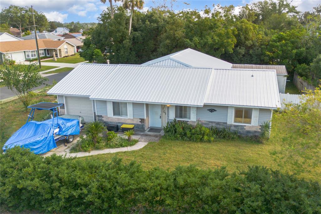 a aerial view of a house next to a big yard and large trees