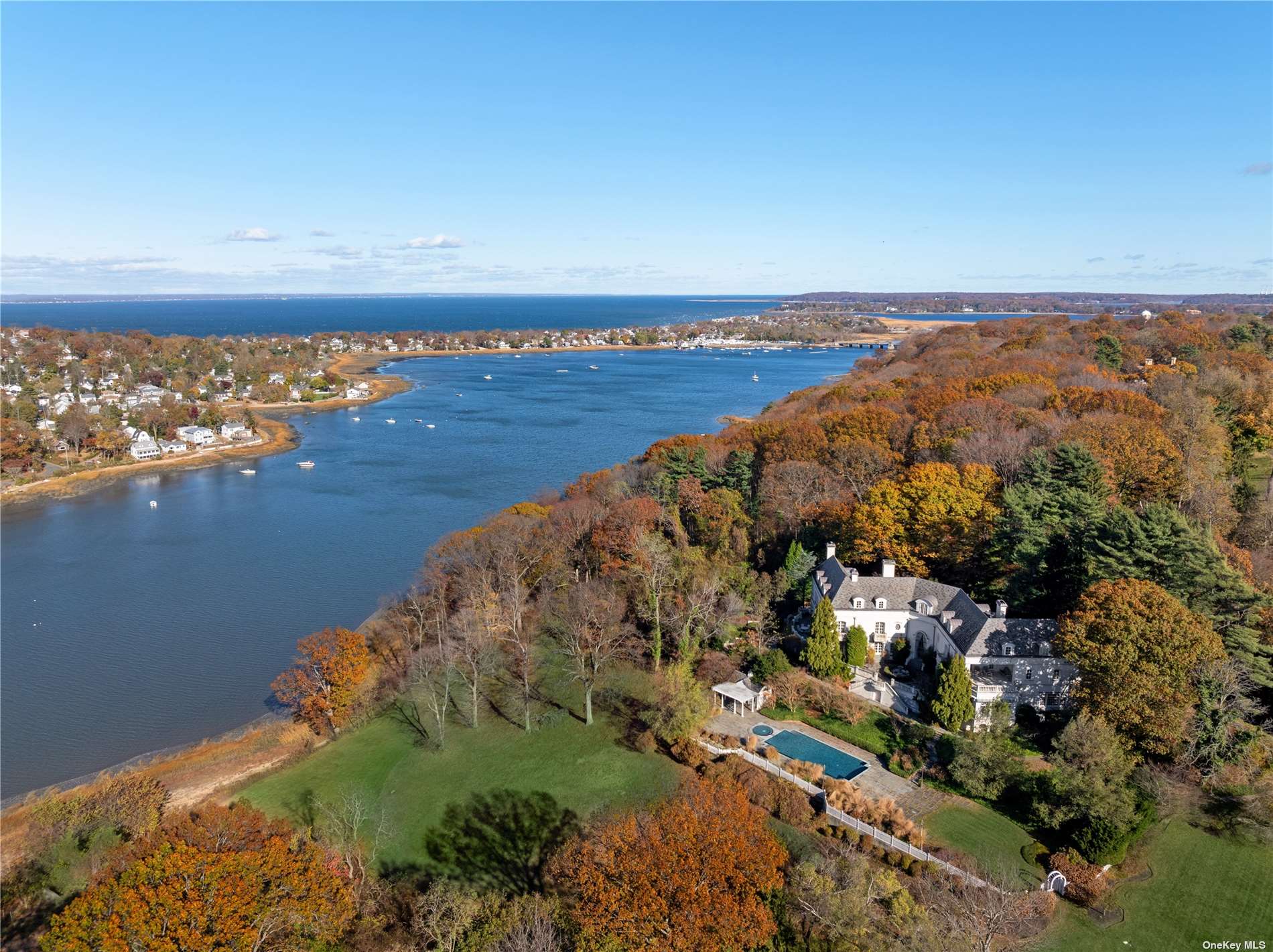 an aerial view of ocean and residential houses with outdoor space