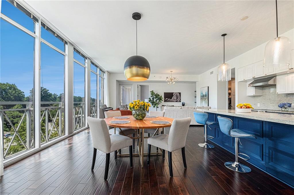 a view of a dining room and livingroom with furniture wooden floor a chandelier