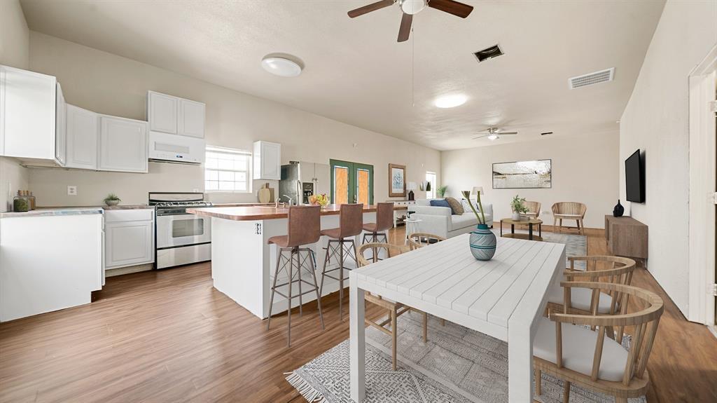 a kitchen with a table chairs refrigerator and cabinets