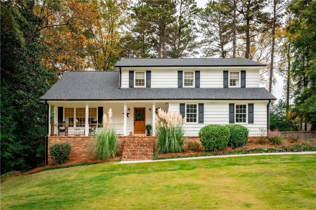 a front view of a house with a yard and trees