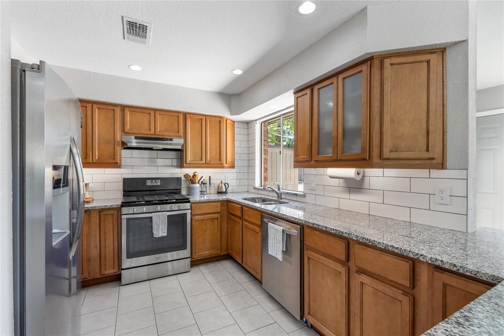 a kitchen with stainless steel appliances granite countertop a sink stove and cabinets