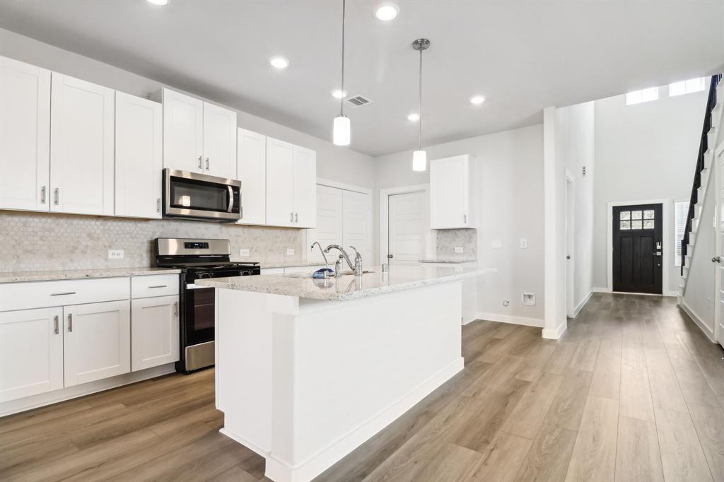 a kitchen with a sink a microwave a stove and refrigerator