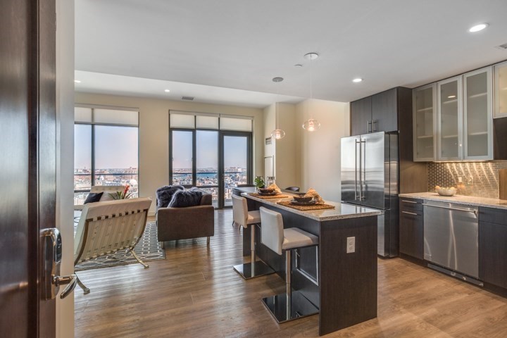 a view of a kitchen with kitchen island granite countertop a table chairs sink and wooden floor