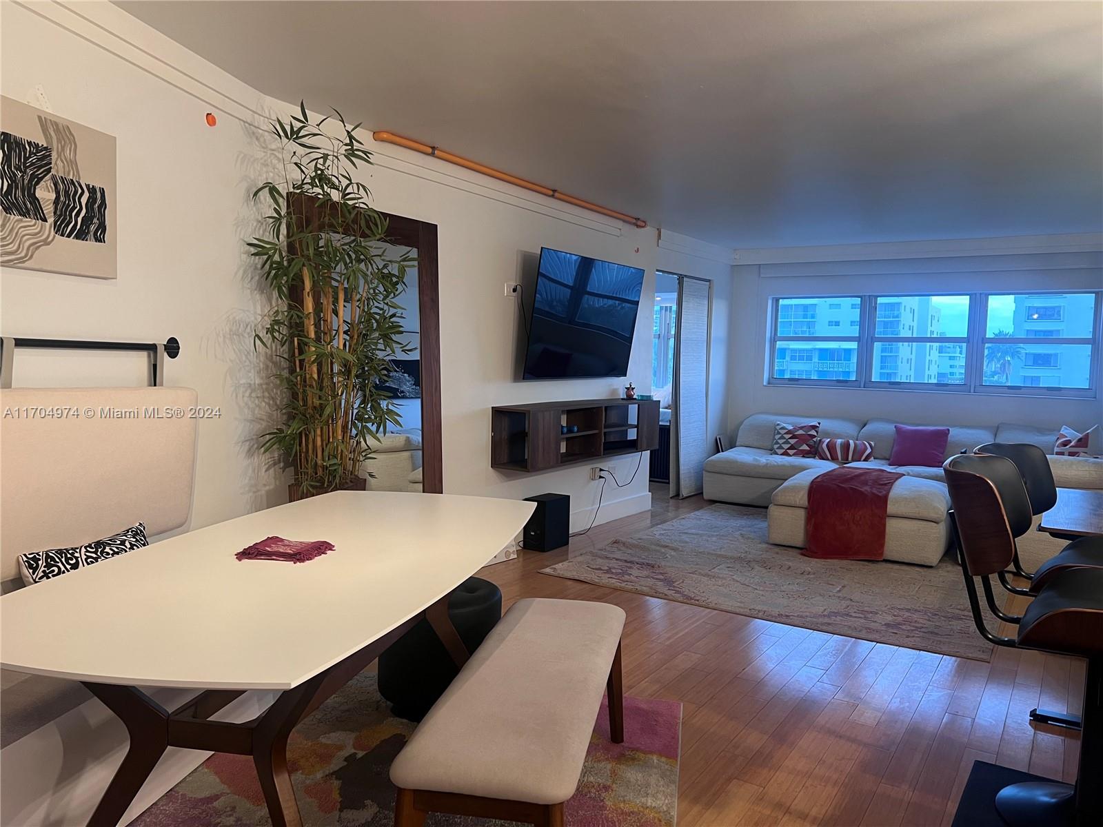 a living room with furniture a flat screen tv and a table