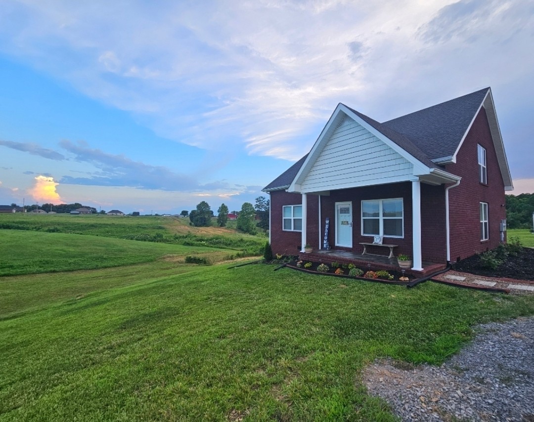 a view of a house with a yard and porch