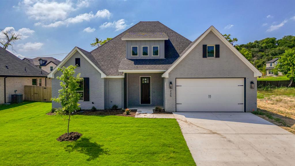 a front view of house with a yard and green space