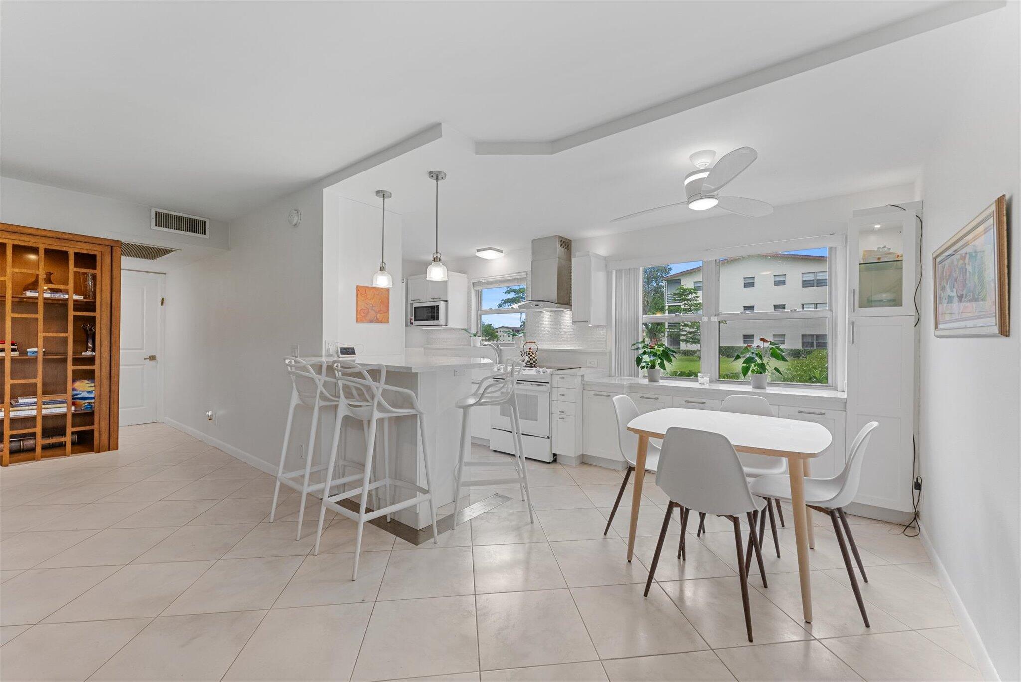 a kitchen with a dining table chairs and white cabinets