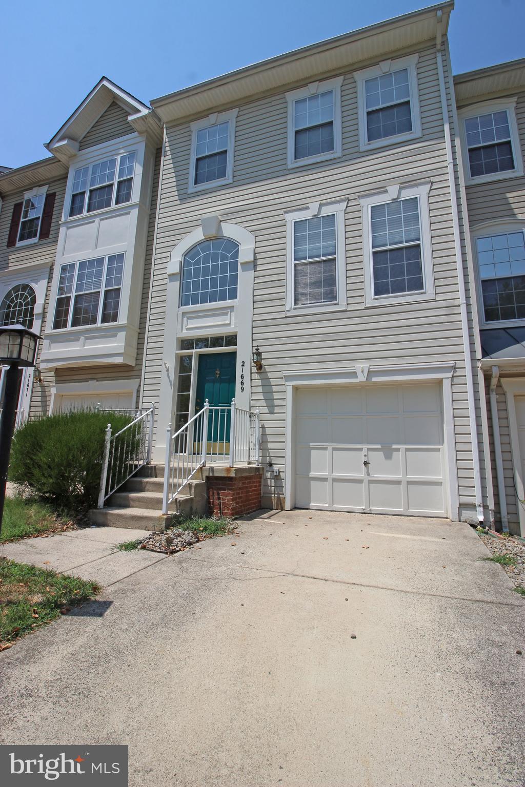 a front view of a house with a yard and a garage