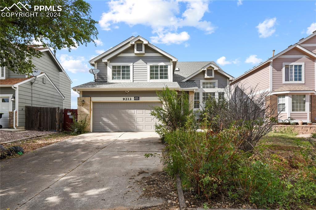 a front view of a house with a yard and garage