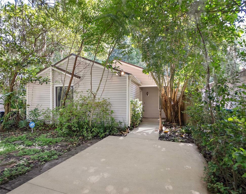 a front view of a house with a yard and tree