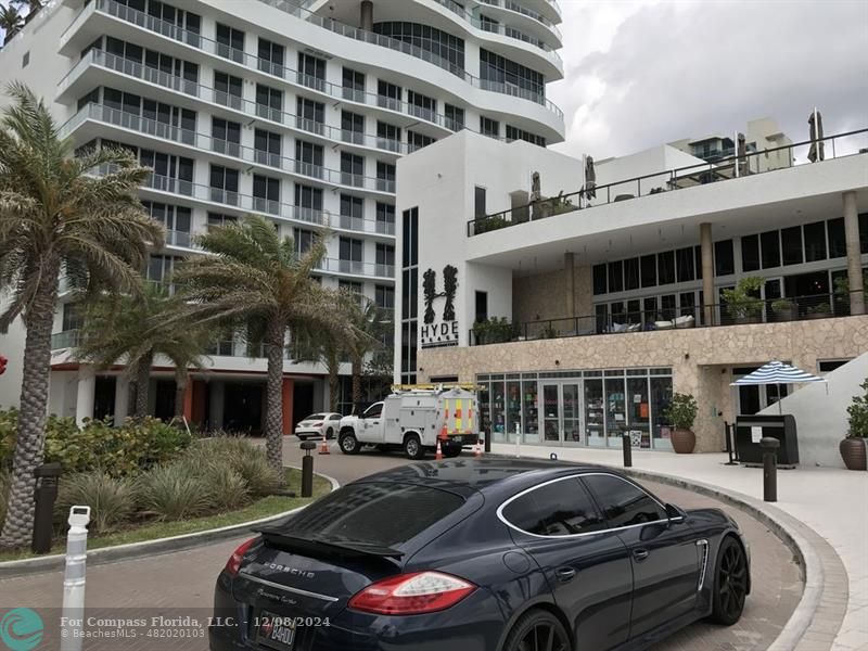 a front view of a building with cars parked