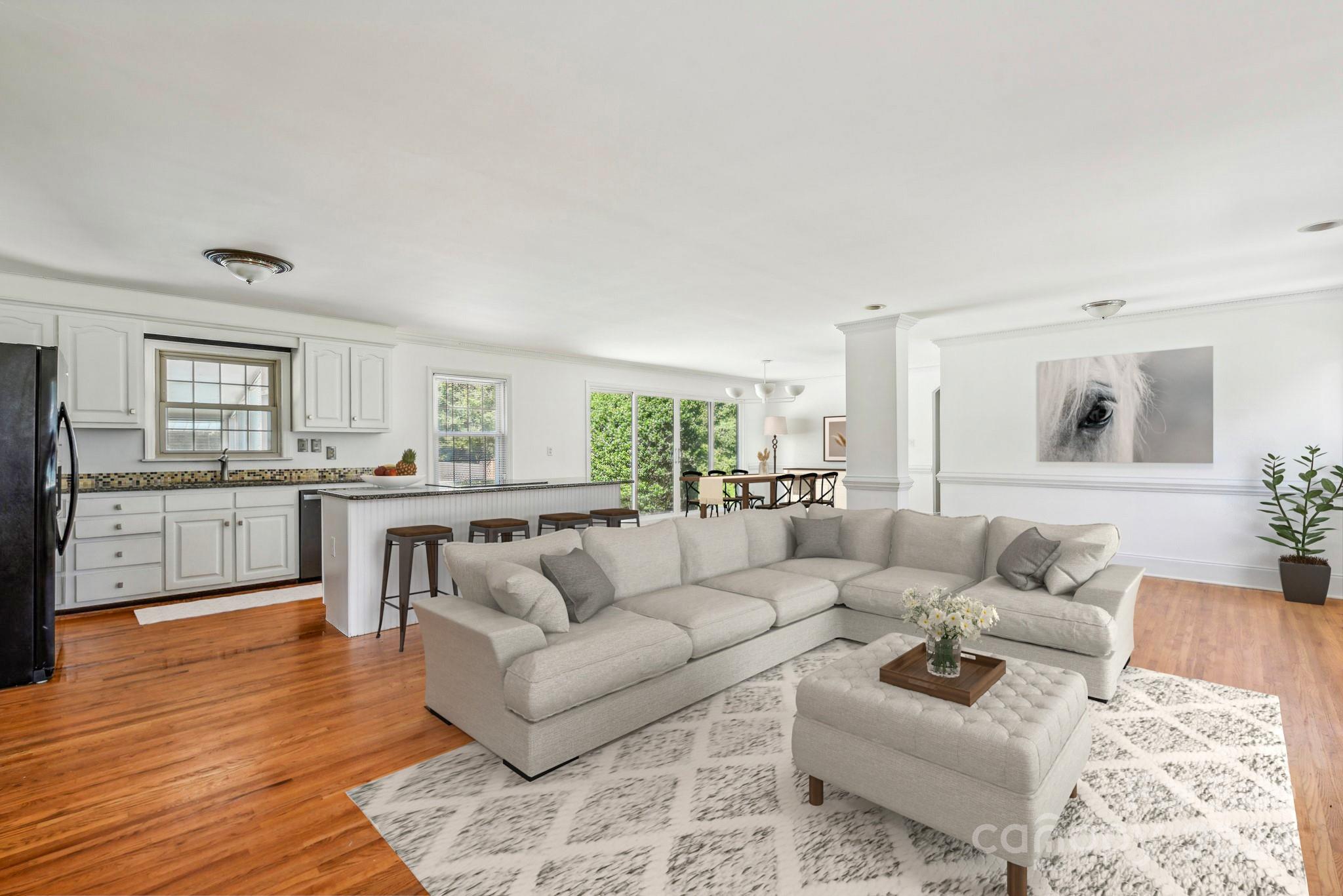 a living room with furniture and view of kitchen