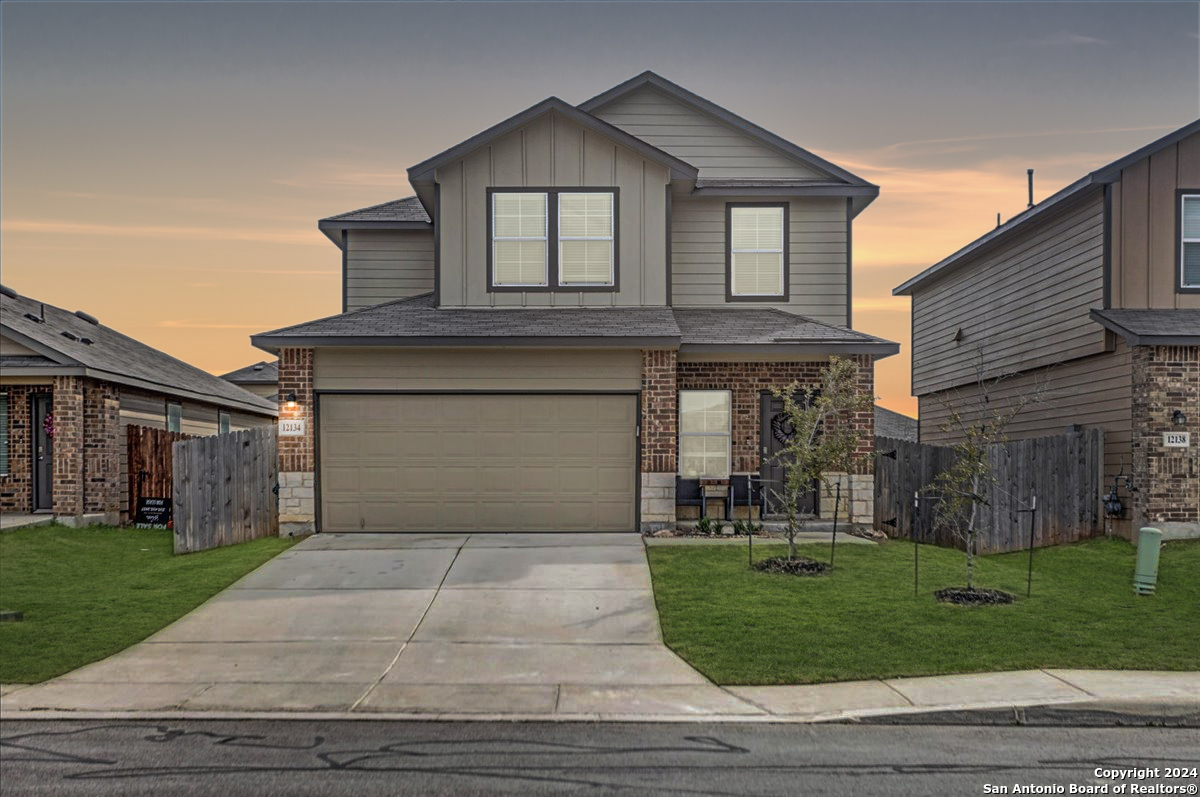 a front view of a house with a yard and garage