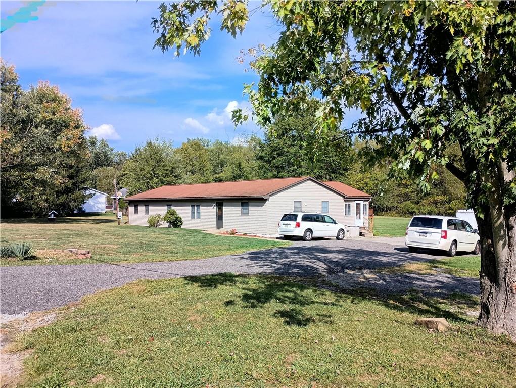 a front view of a house with a yard and trees