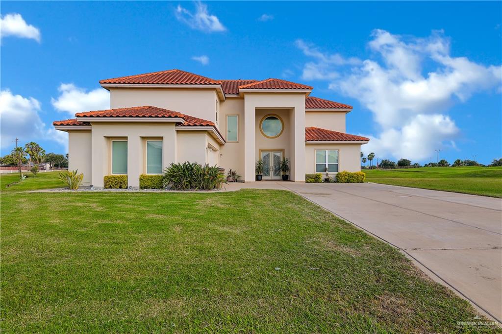 Mediterranean / spanish house with a front lawn