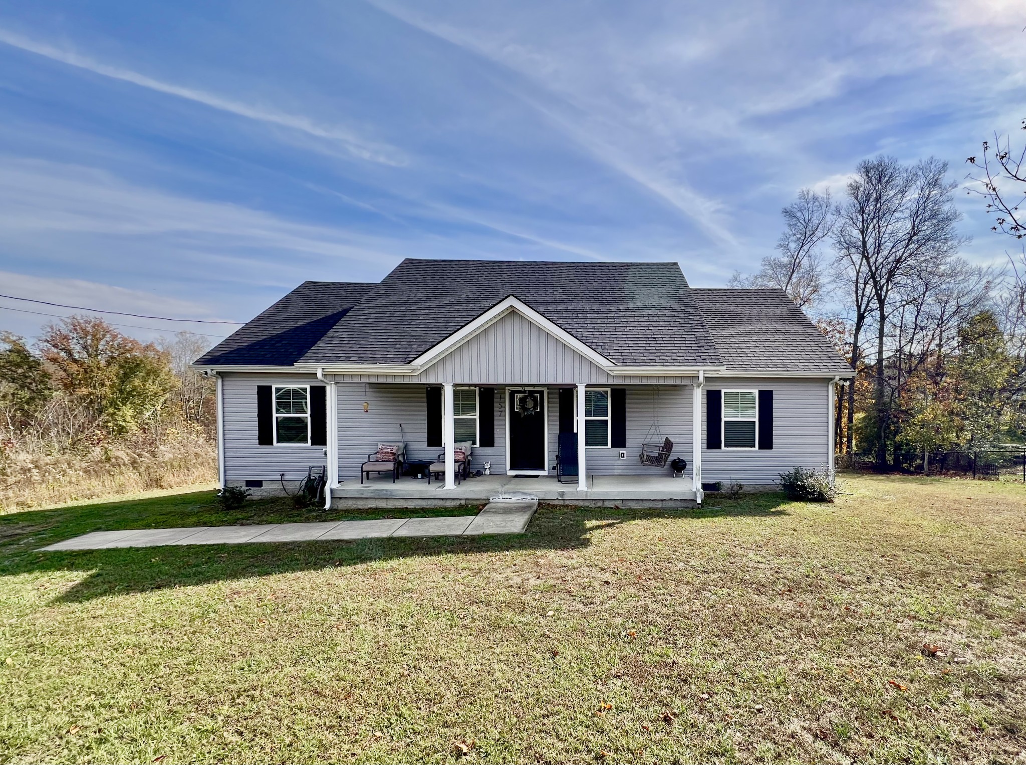 a front view of a house with a yard and trees