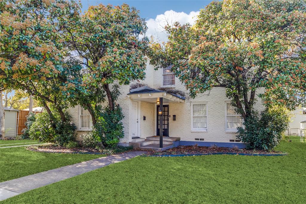 a view of a white house with a big yard and large trees