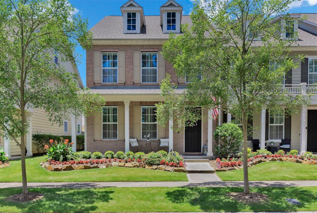 The home boasts exceptional curb appeal with its classic brick exterior, symmetrical design, and beautifully landscaped front yard.