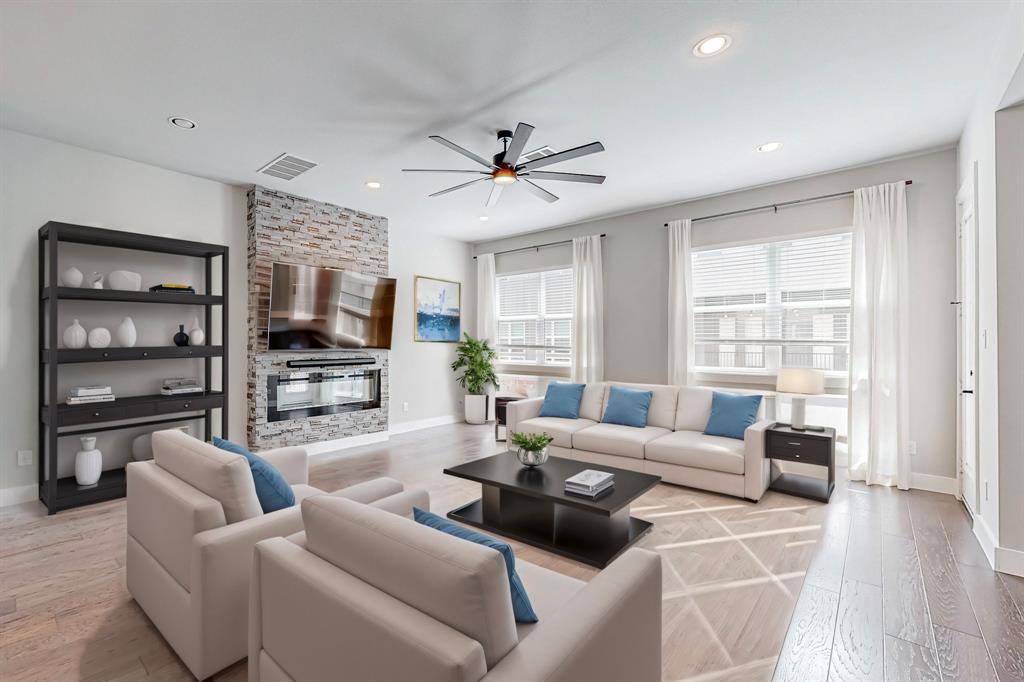 a living room with furniture a ceiling fan and a flat screen tv