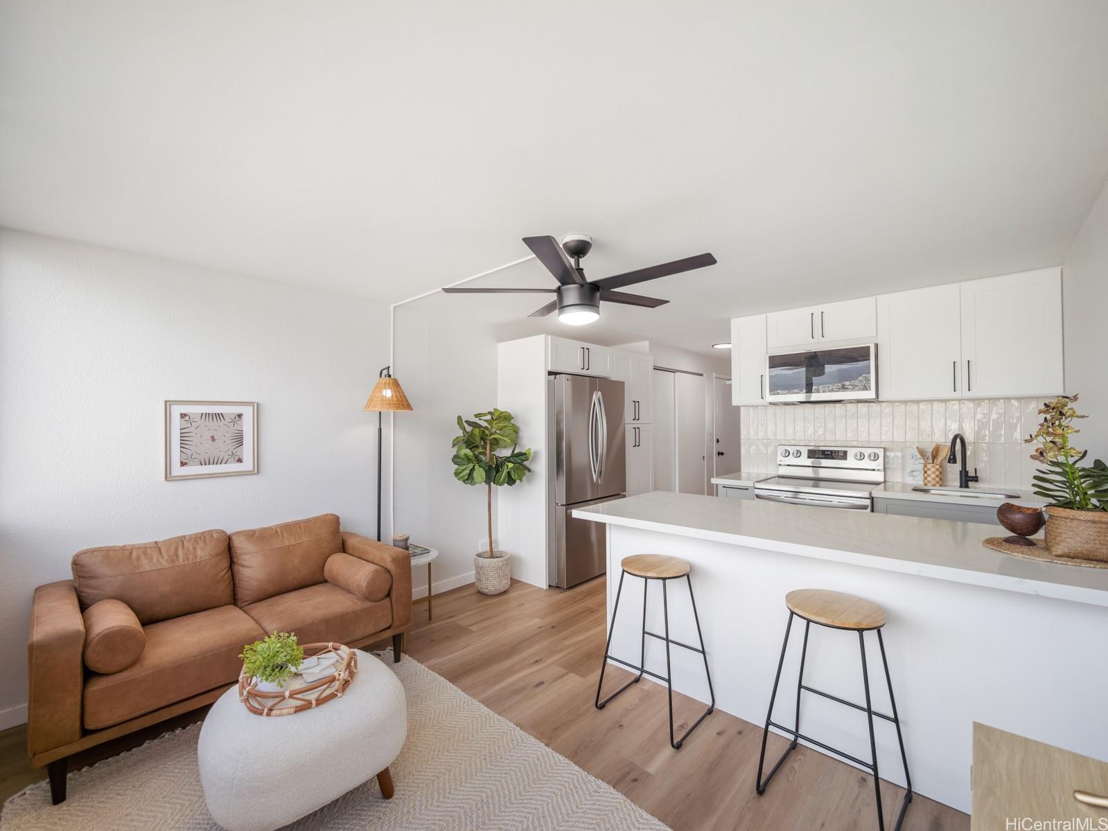 a living room with furniture and a dining table with kitchen view