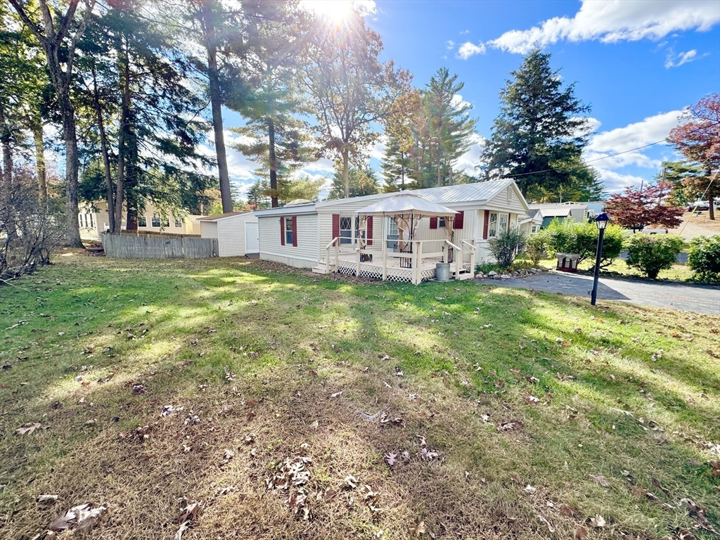 a view of a house with a yard and sitting area