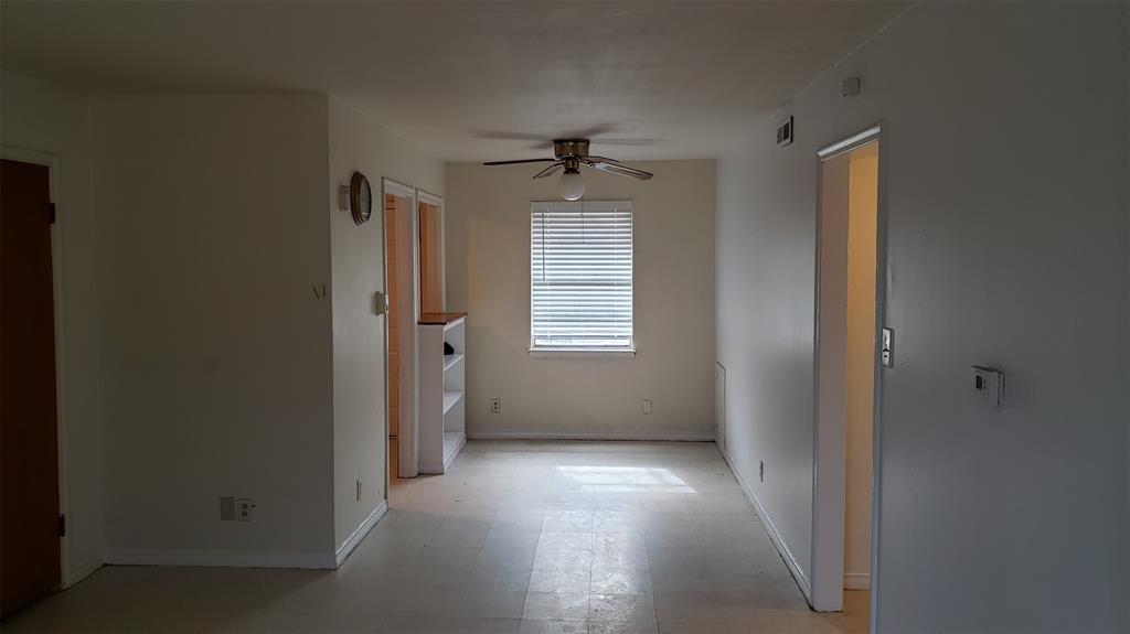 an empty room with windows and cabinet