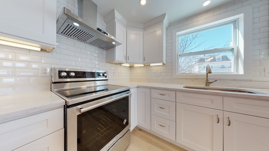 a kitchen with white cabinets and appliances