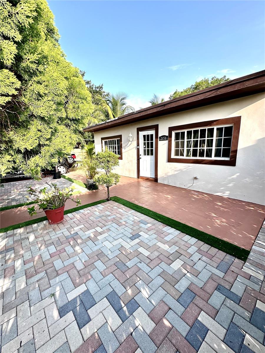 a front view of a house with a yard and potted plants