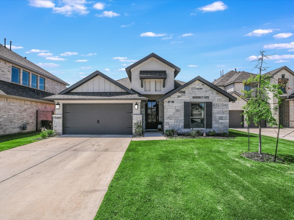 a front view of a house with a yard and garage