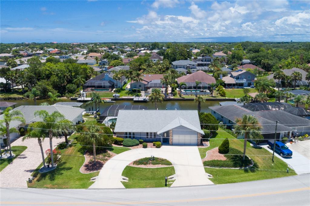 an aerial view of residential houses with outdoor space and a lake view