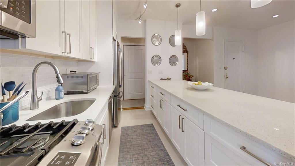 a kitchen with granite countertop a sink stove and cabinets