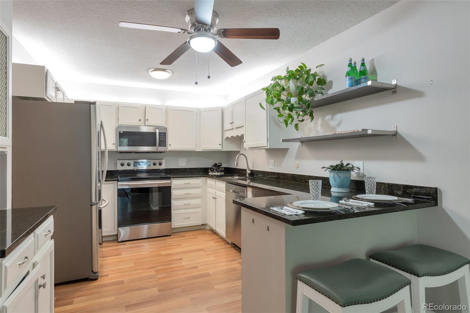 a kitchen with kitchen island granite countertop stainless steel appliances a sink stove and refrigerator