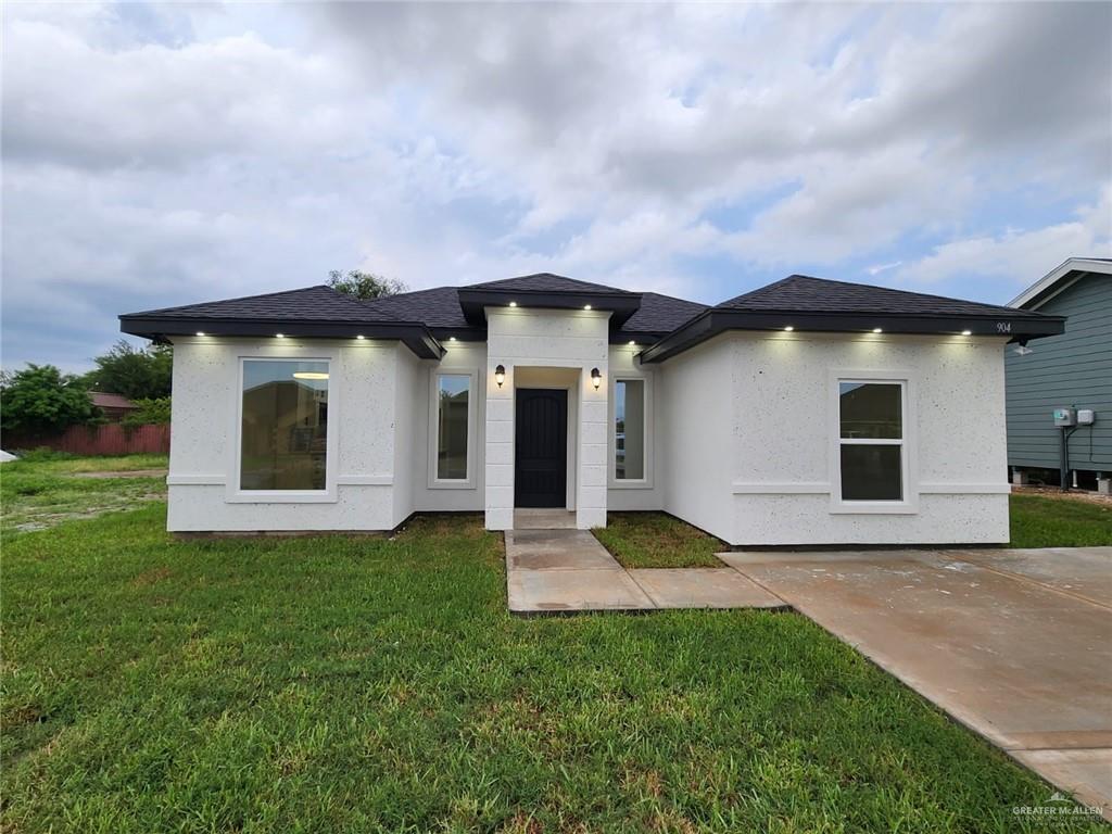 View of front of property with a patio area and a front yard