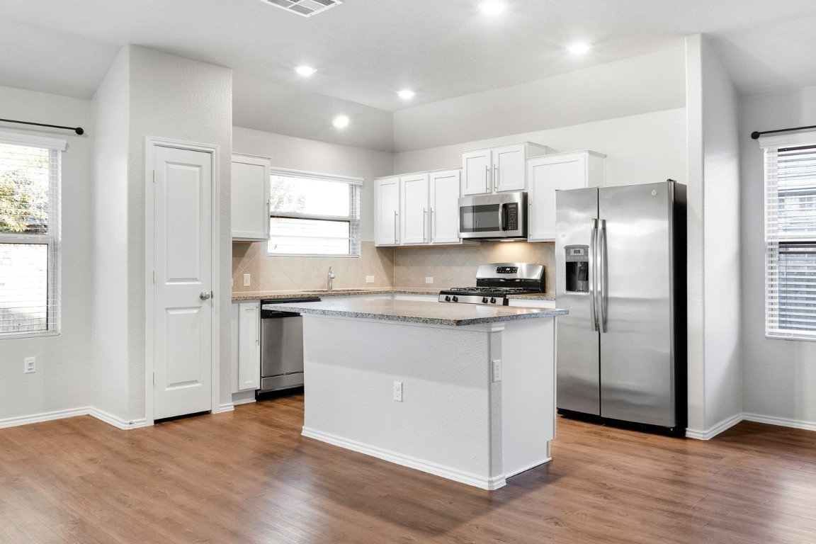 a kitchen with stainless steel appliances a refrigerator sink and microwave