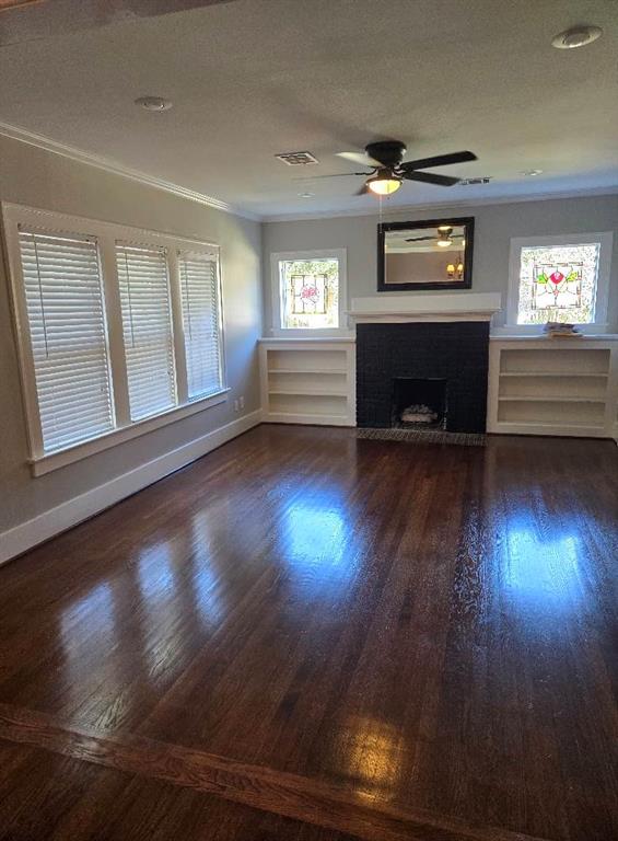 a view of a livingroom with wooden floor a fireplace and window