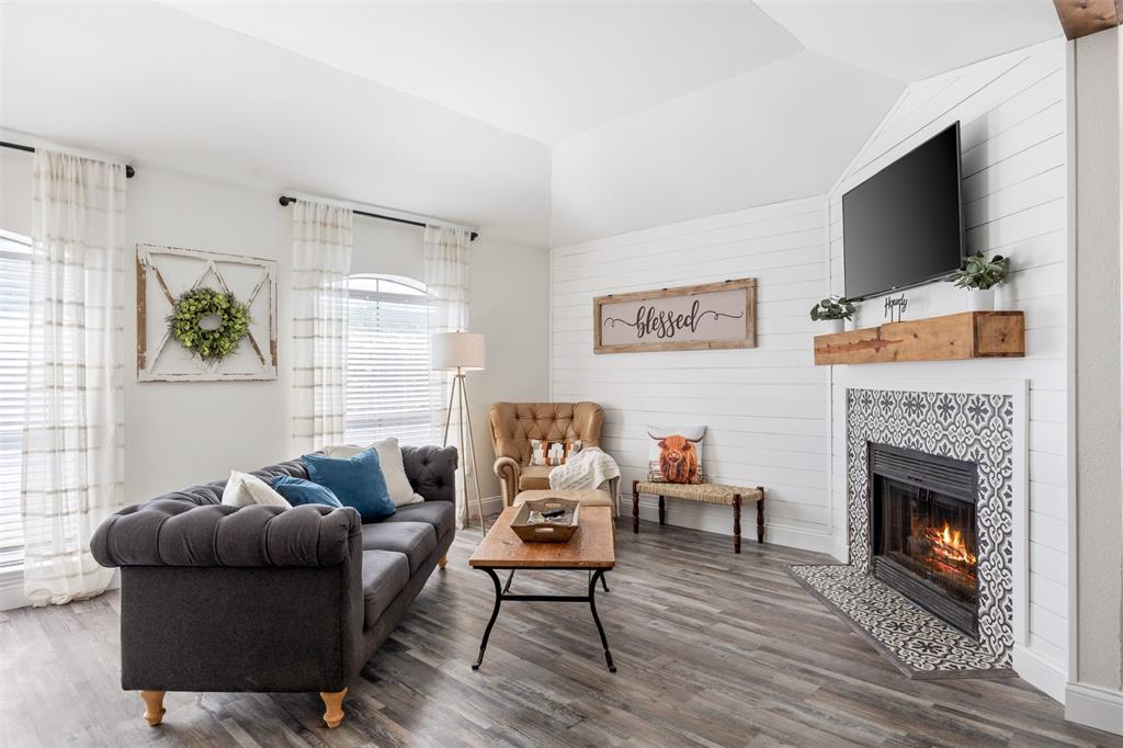 a living room with furniture a flat screen tv and a fireplace