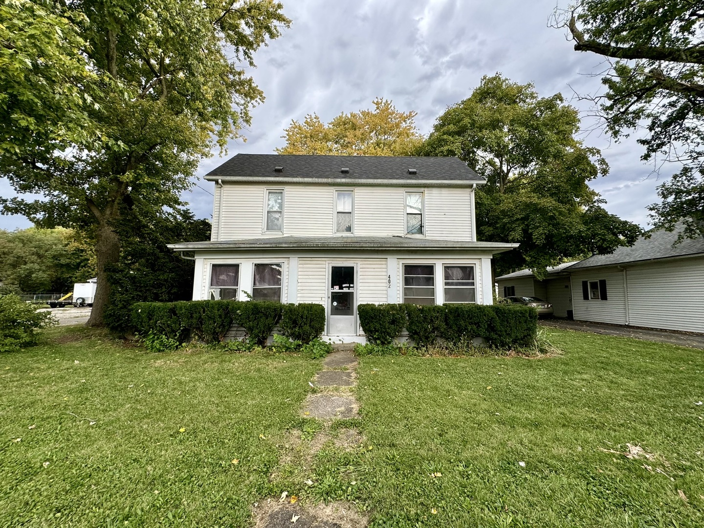 a front view of a house with a yard and trees