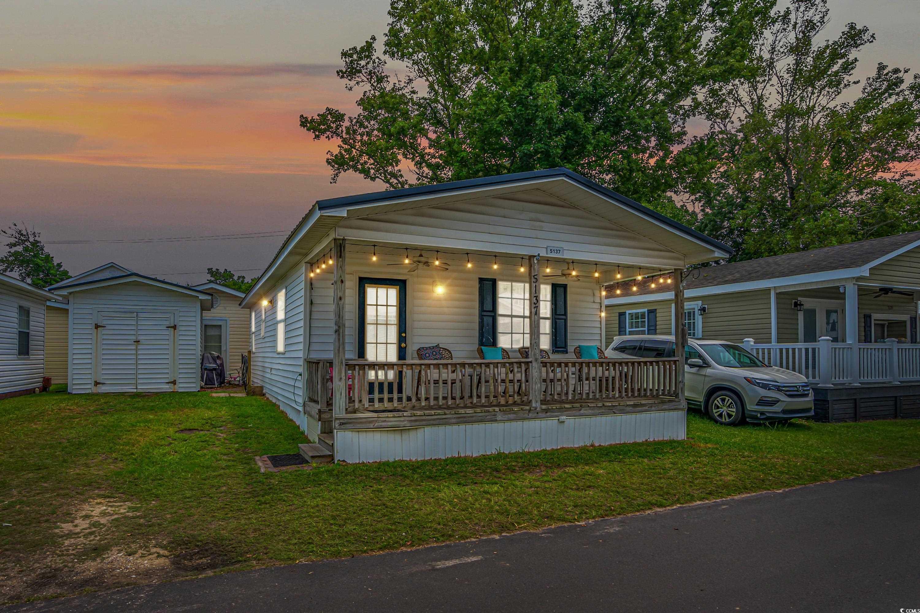 View of front of home with a porch, a lawn, and a