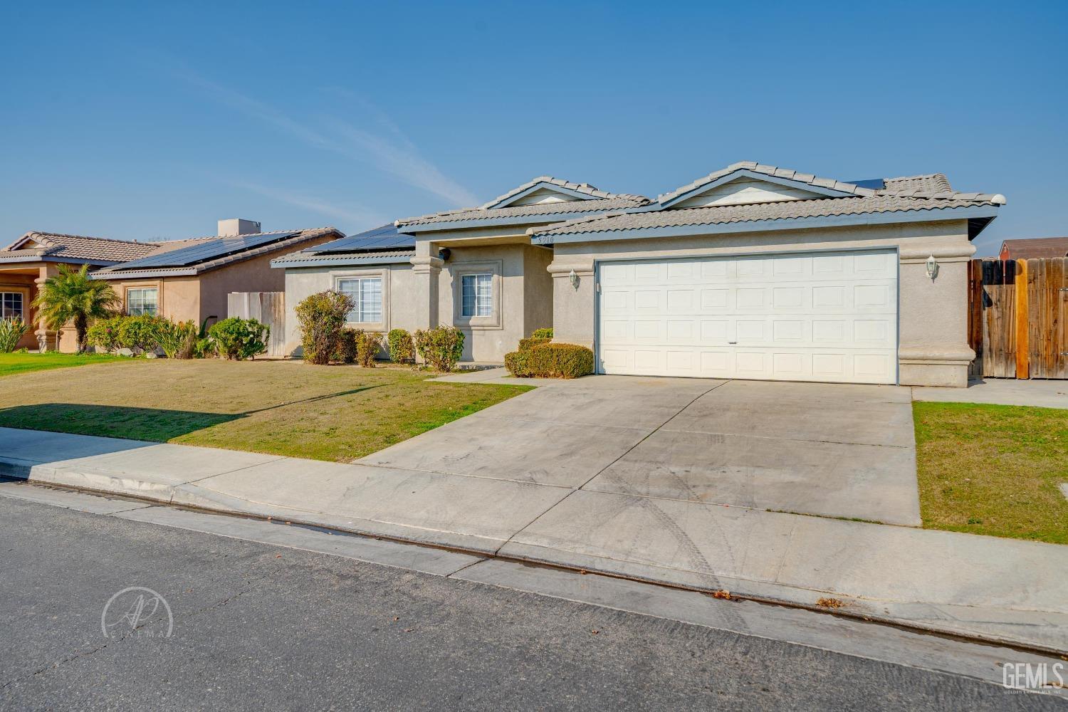 a view of a house with a yard and large parking space