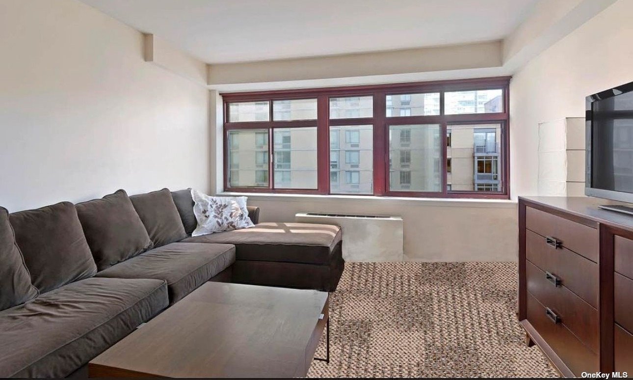 a living room with furniture and large windows