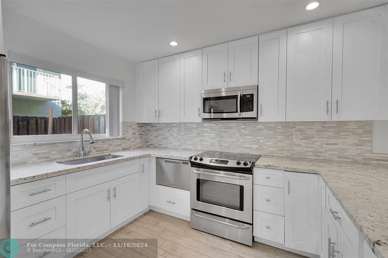 a kitchen with appliances a sink and cabinets