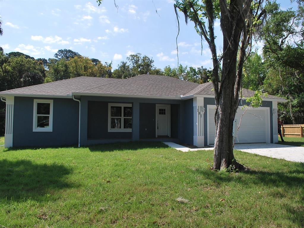 a front view of a house with a yard and trees