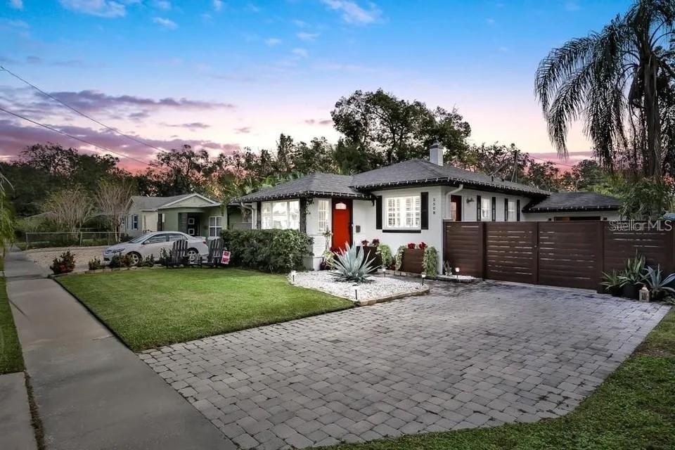 a front view of a house with a yard and mountain view