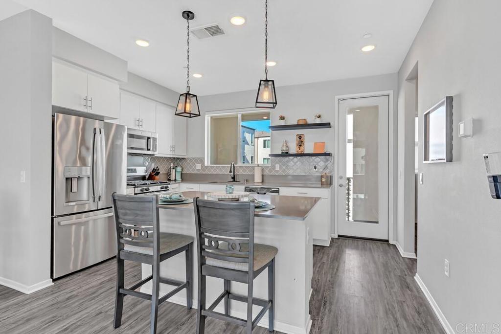 a kitchen with kitchen island white cabinets and stainless steel appliances