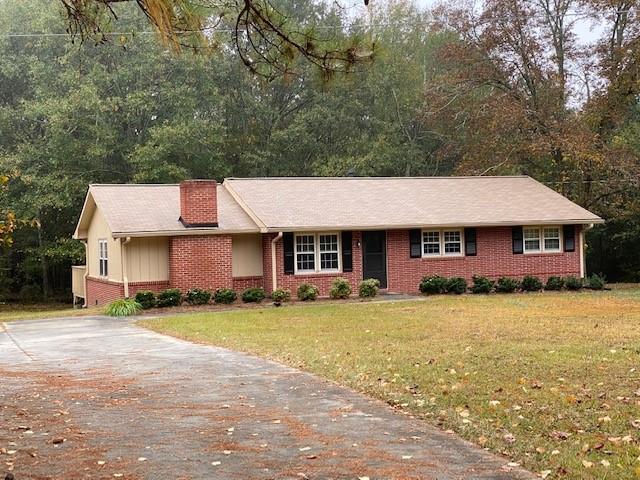 a view of a house with a big yard and large trees