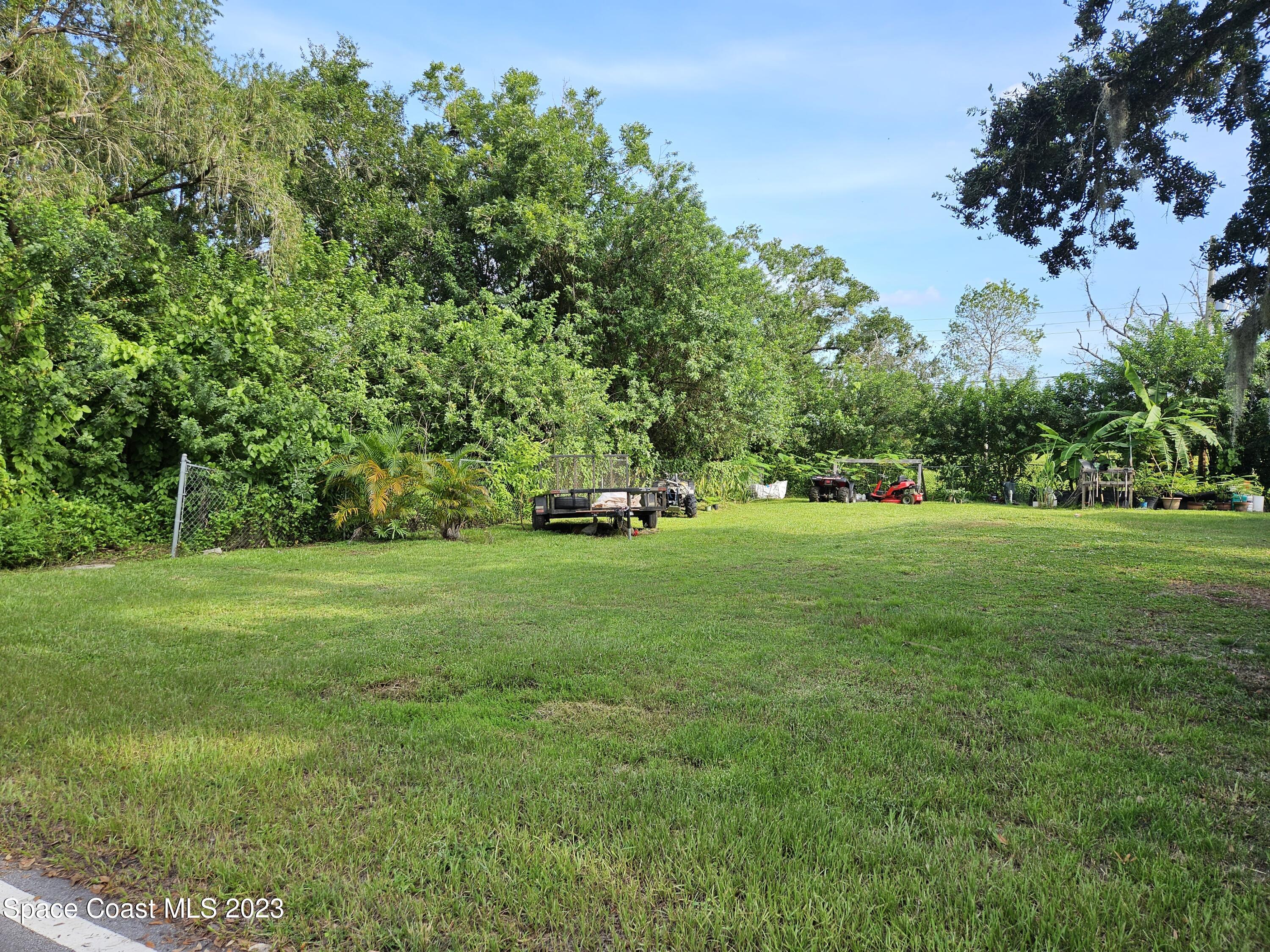 a view of green field with trees in the background