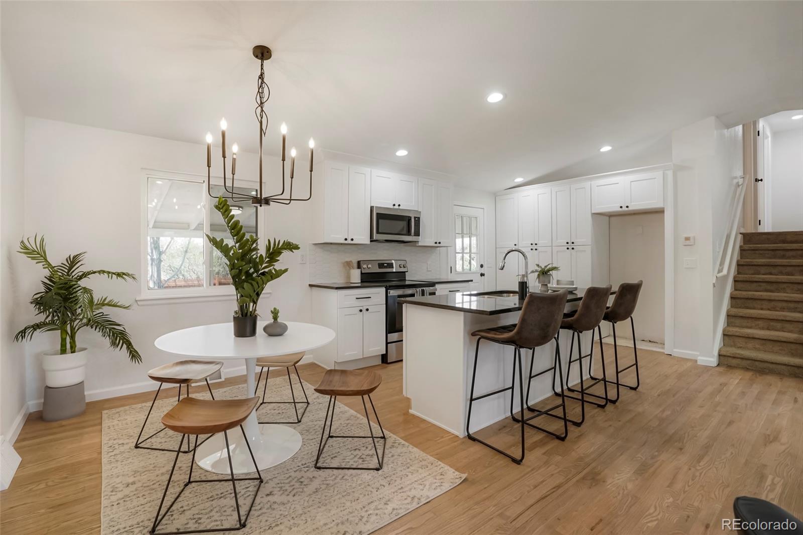 a view of a dining room with furniture a chandelier and wooden floor