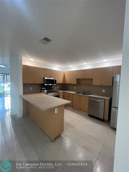 a large white kitchen with a large window