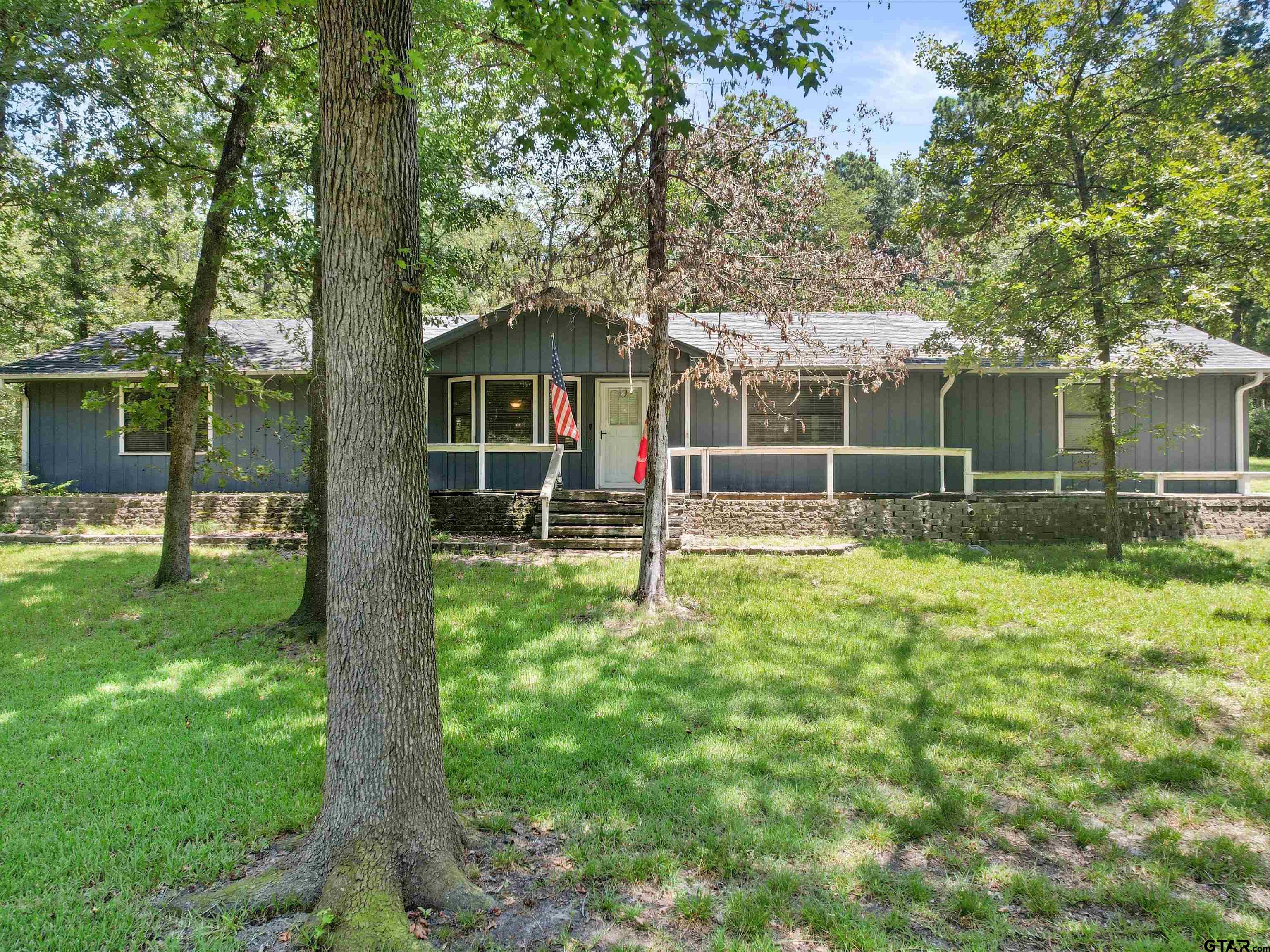 a view of a house with backyard and a tree